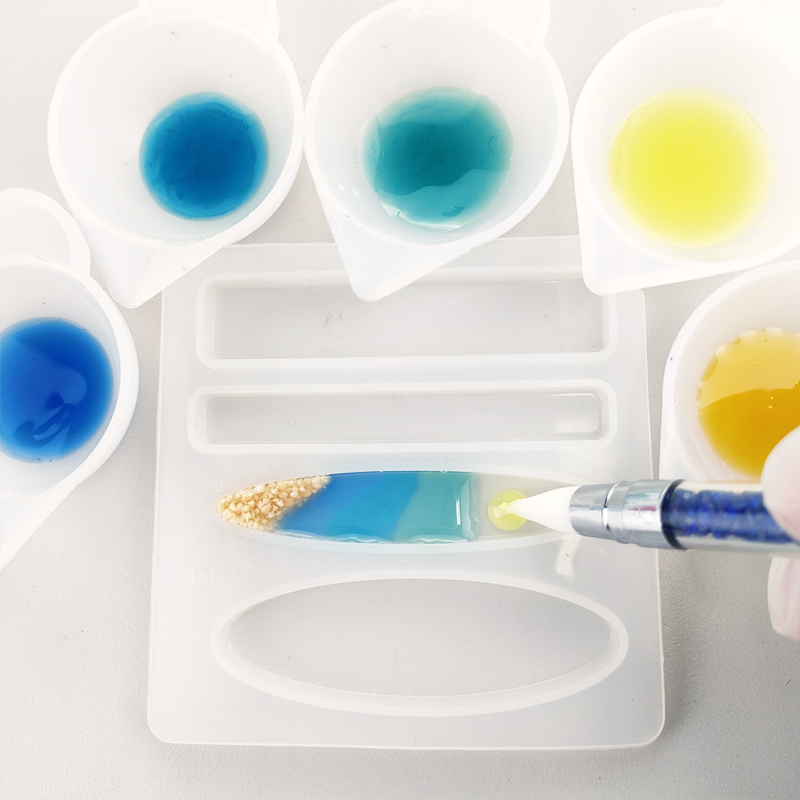 ヘアピンの作り方 着色剤を混ぜ合わせた5色のUVレジンをモールドに流している写真